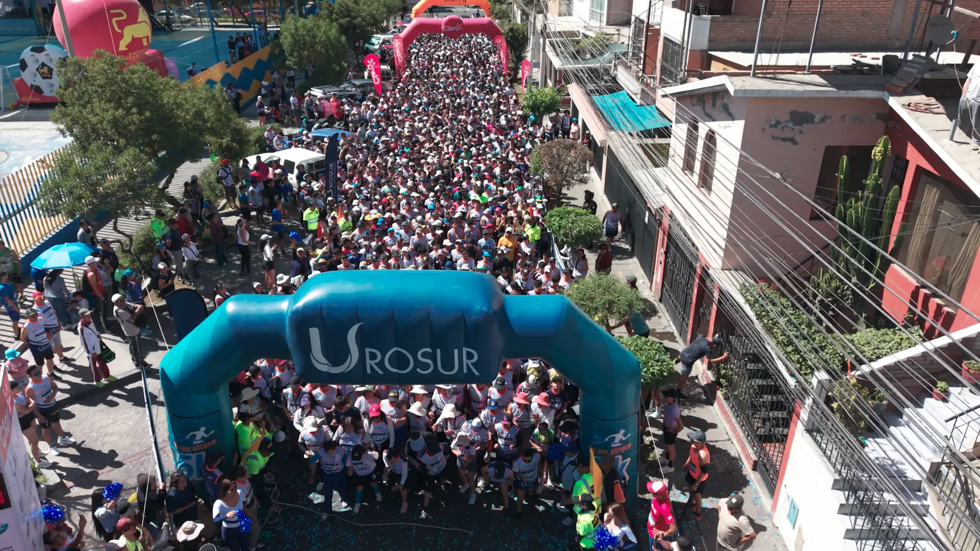 Vista aérea de cientos de corredores en la partida de la carrera 5K Noviembre Azul, bajo el arco de Urosur
